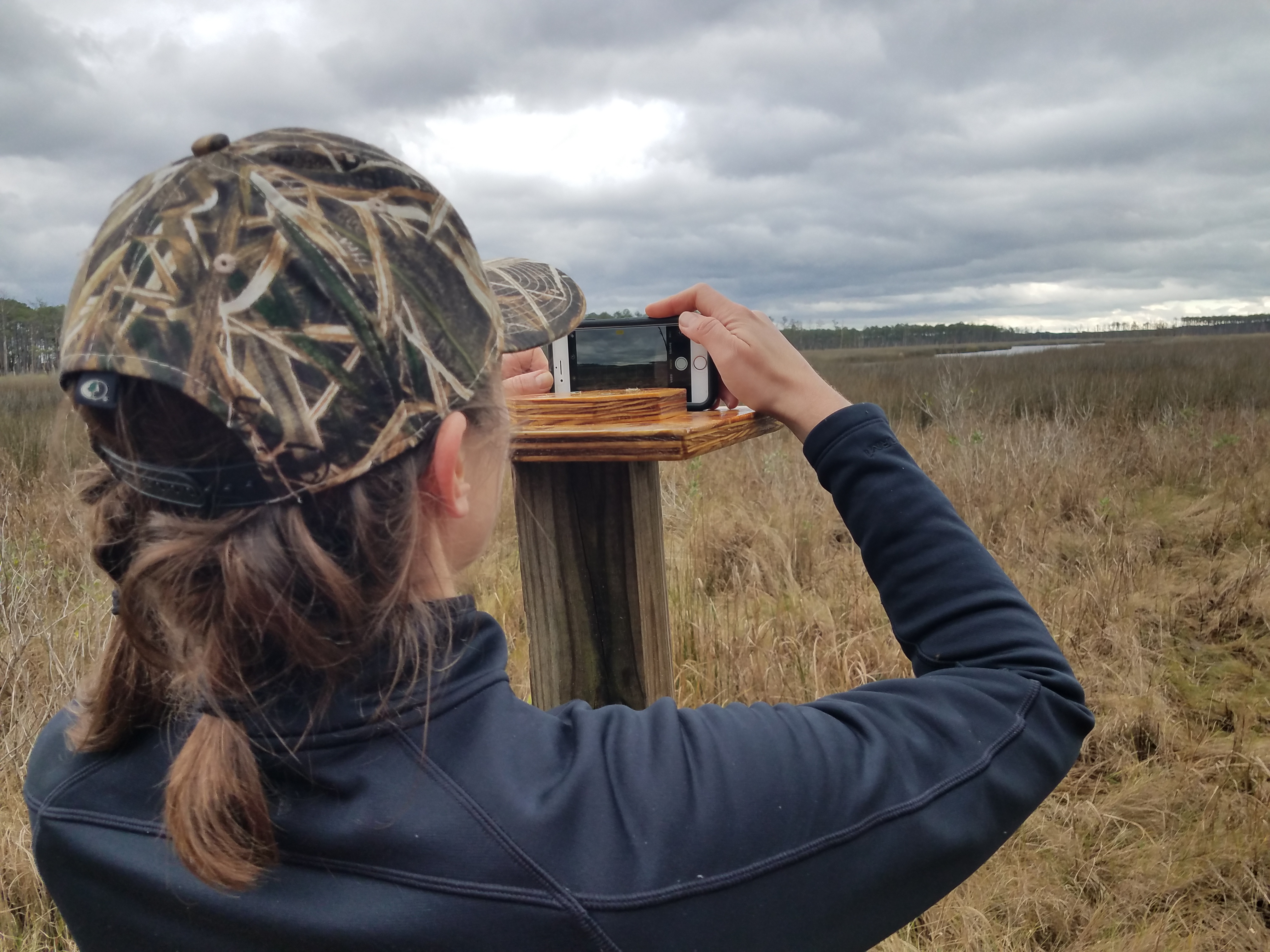 A woman postitions a cell phone on a photo platform.