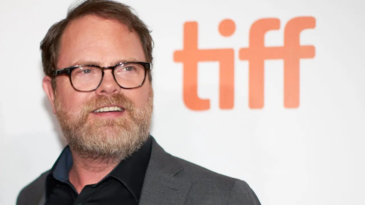 Rainn Wilson wearing glasses with the word tiff in the background.