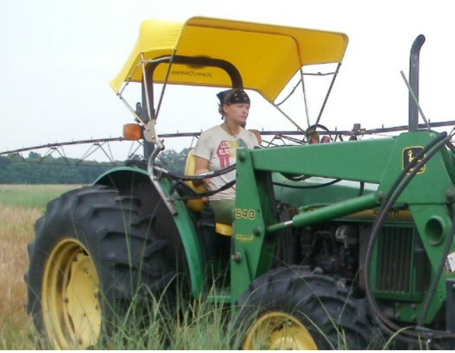 Nature Conservancy staff riding a tractor.