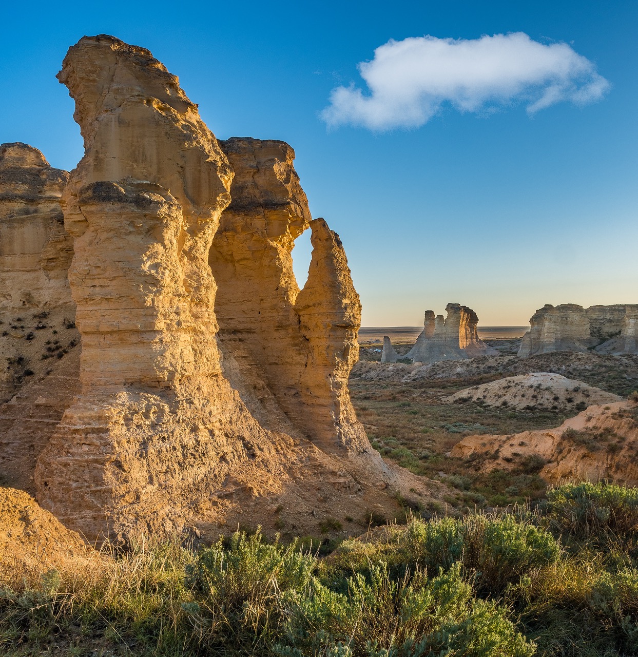 A sedimentary rock formation climbs toward a blue sky.