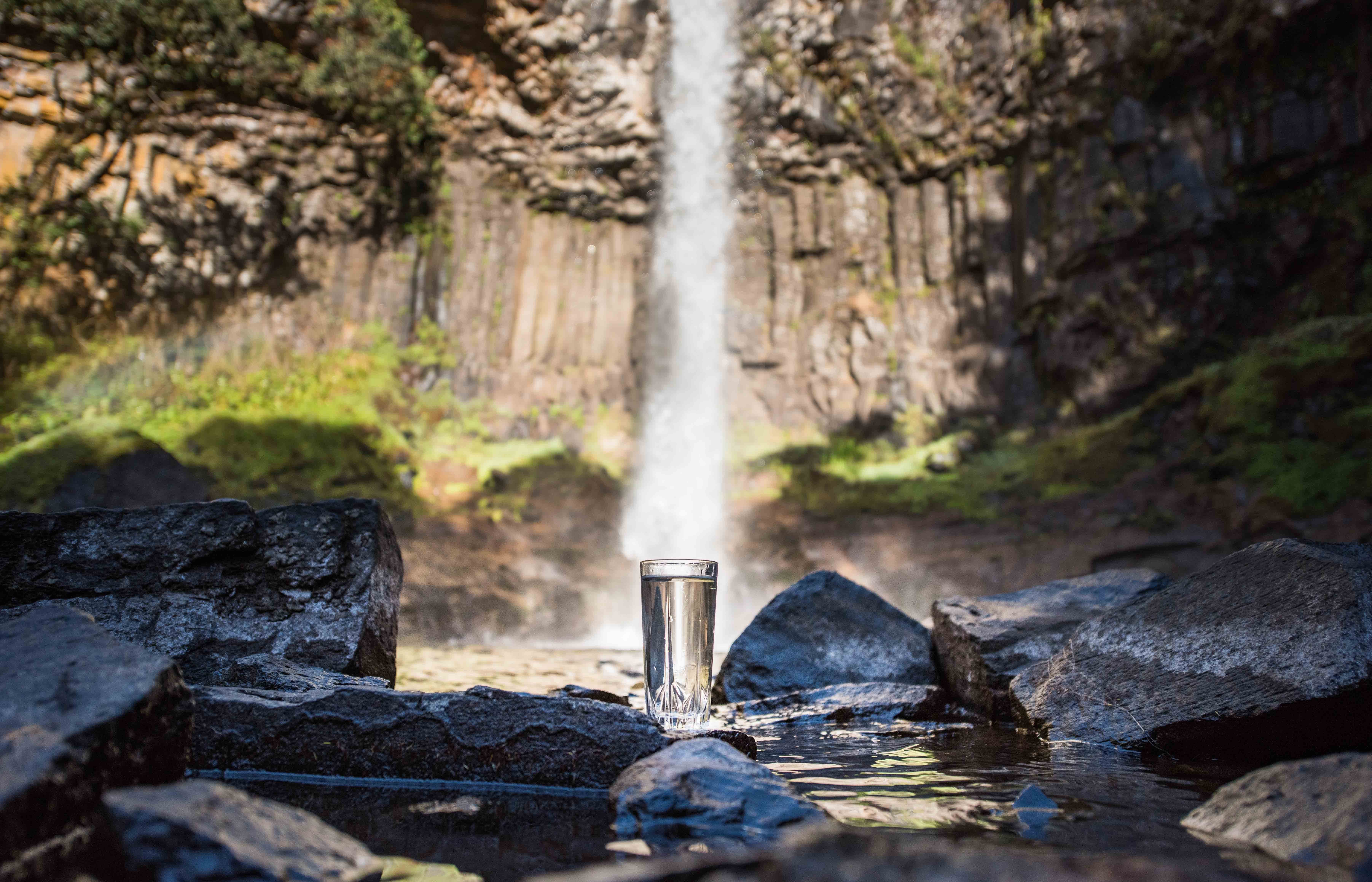 Water flowing from a waterfall into a glass.