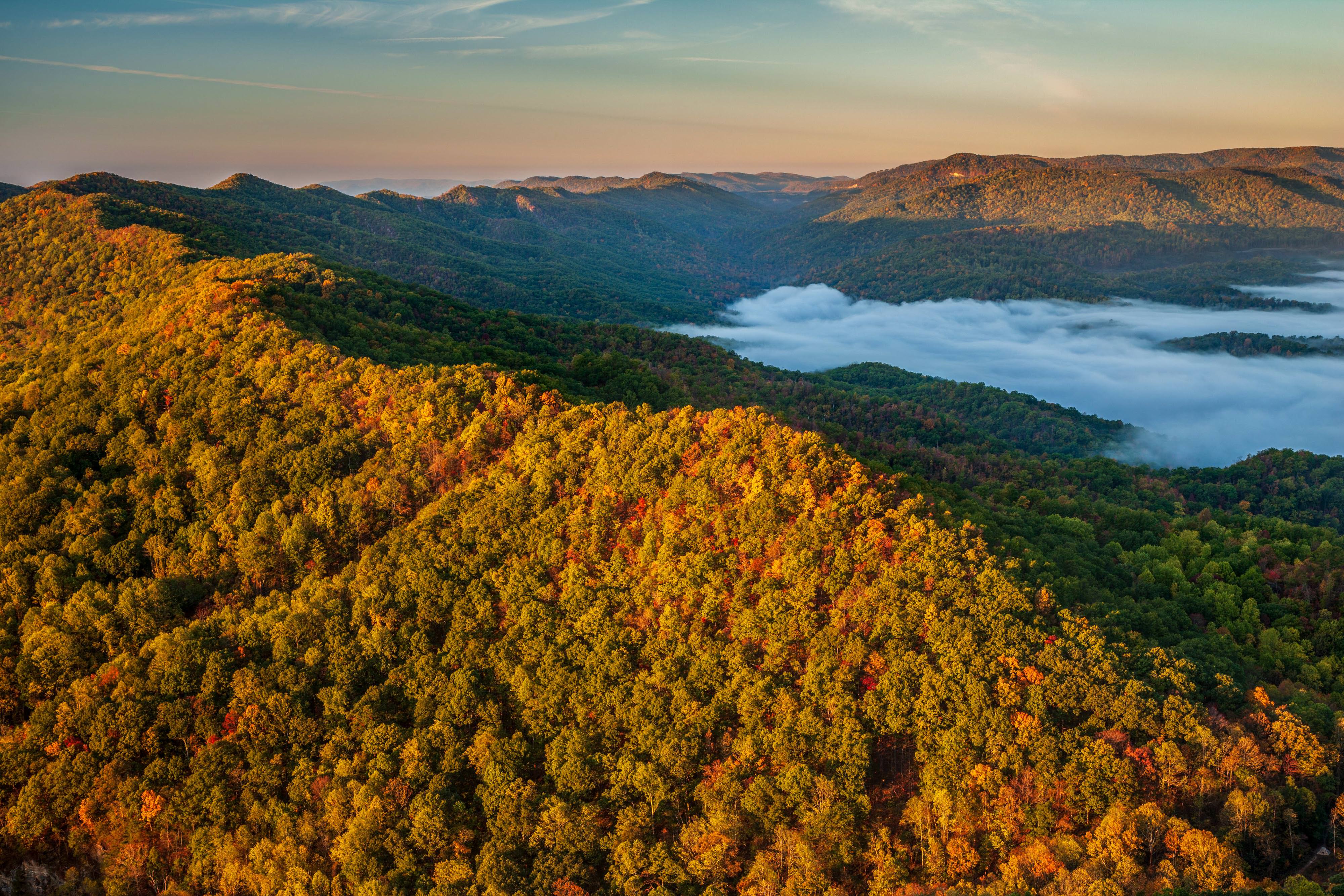 Sunlit mountains of Cumberland Forest, clouds below.