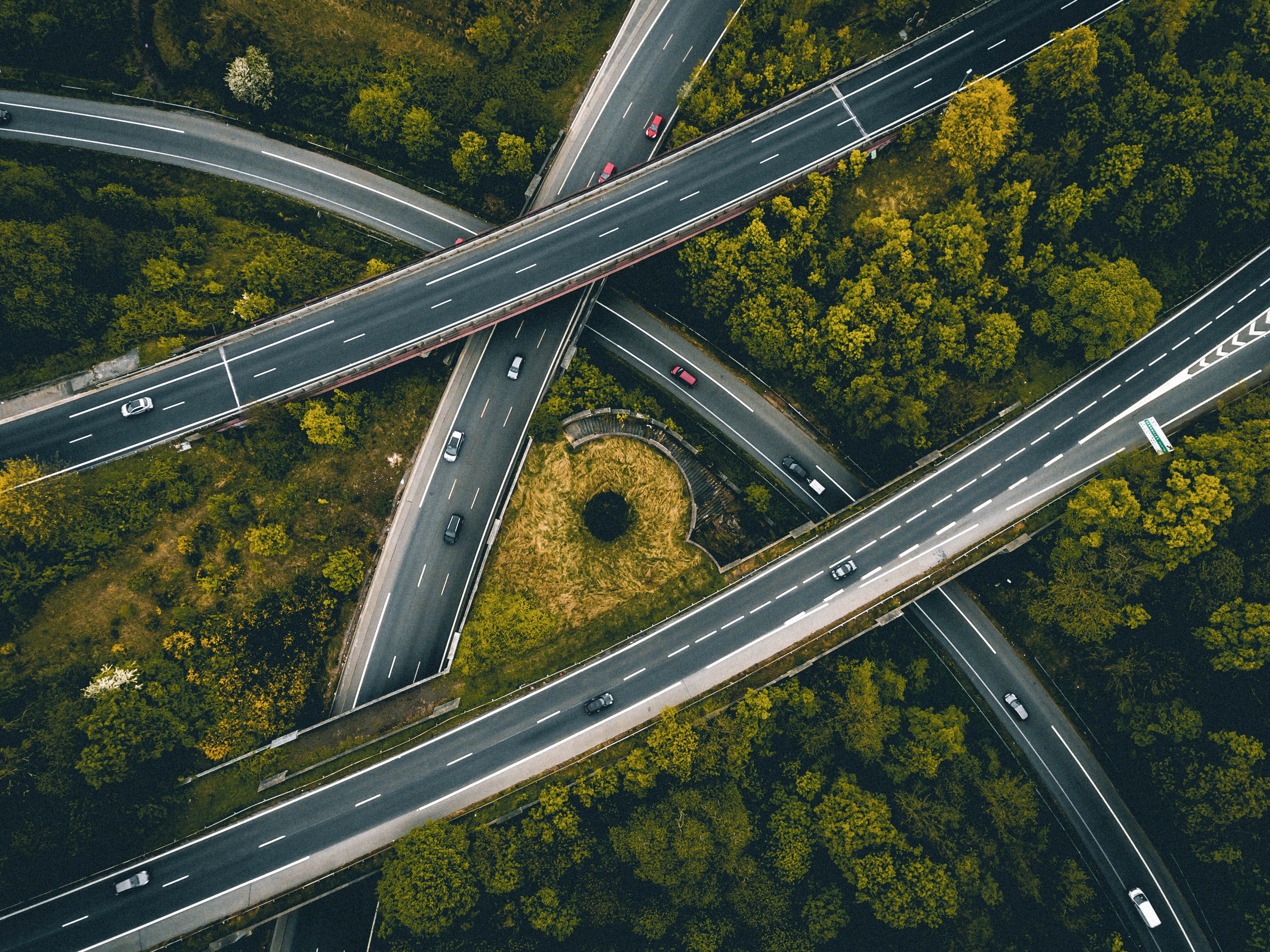 Aerial view of roads cutting through a forest of trees.